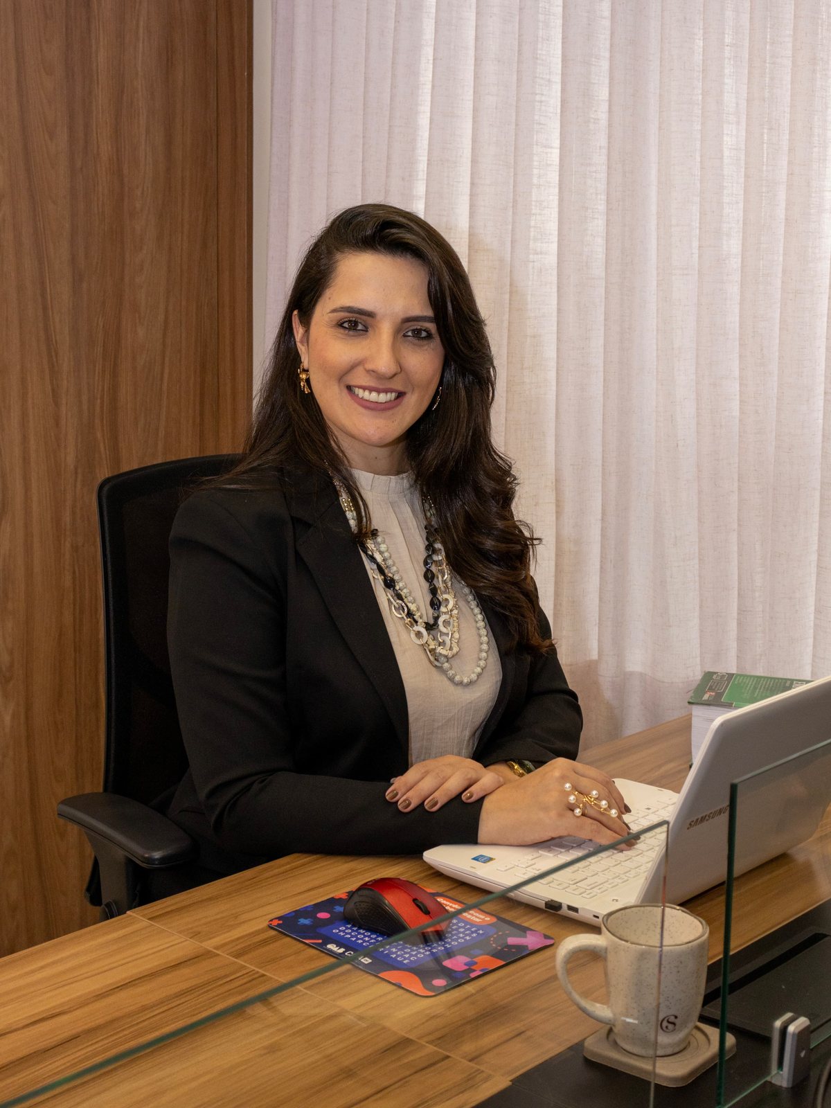 Dra. Larissa Muniz trabalhando em sua mesa no escritório